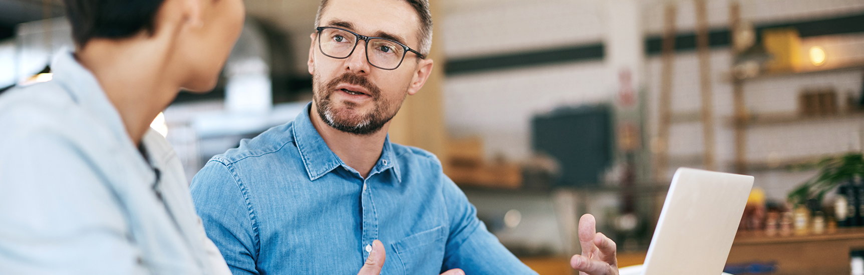 Employers explaining work with employee with laptop