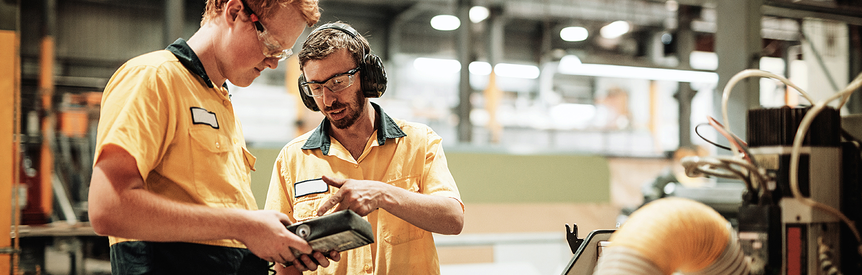 Manufacturing apprentice receiving information from colleague onsite